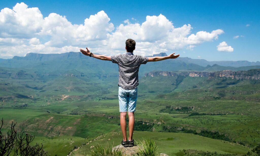 a man standing on a rock with his arms outstretched