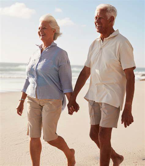 a man and woman holding hands on a beach